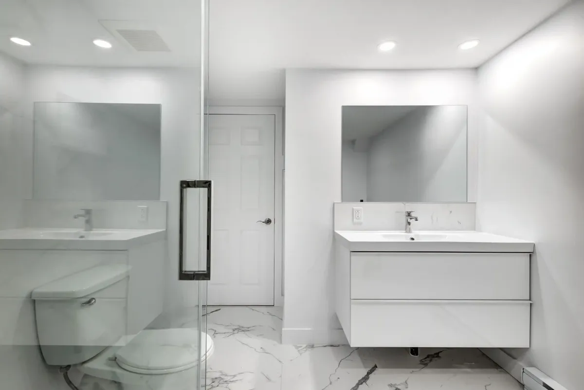 Modern bathroom renovation in St Albert with floating vanity, glass shower and minimalist white design