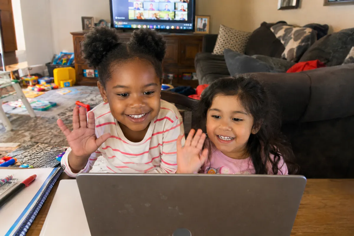 Child waves at laptop