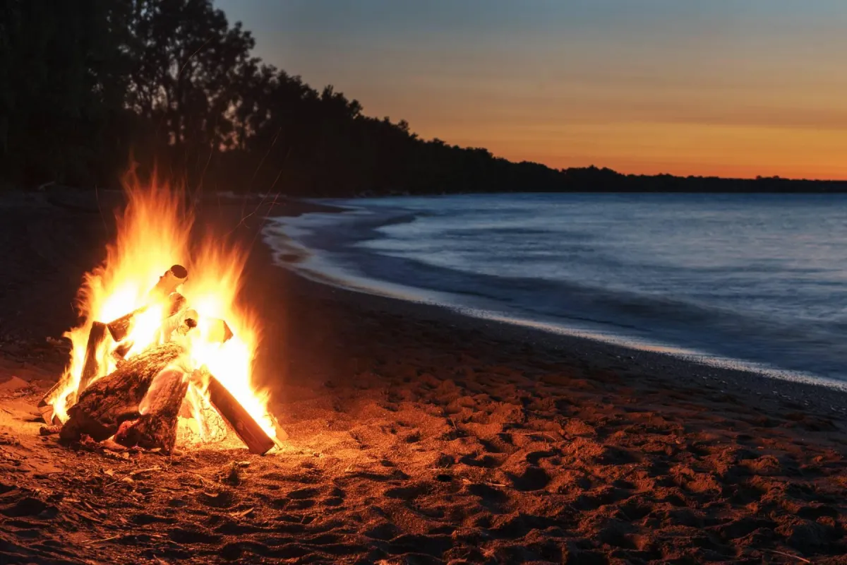 Women 40+ enjoying a bonfire on the beach during group retreat