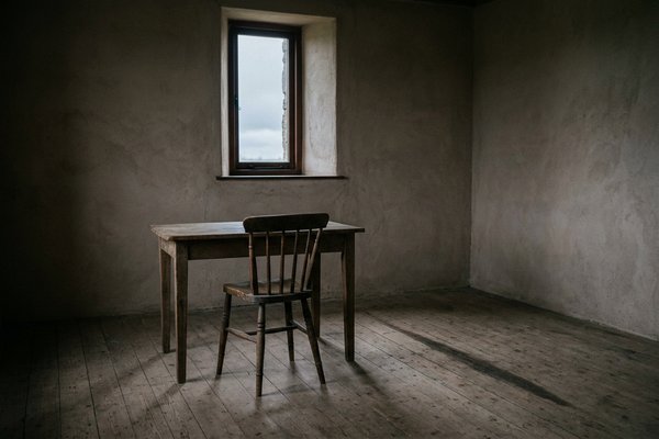 How to stop second guessing yourself, empty chair and table in a bare room with a window