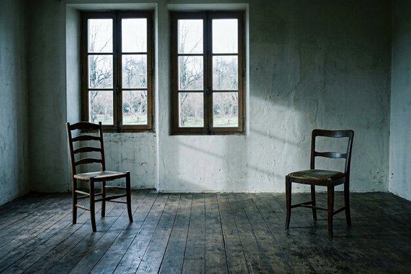 Overthinking in relationships, two empty chairs facing each other in a bare room with two windows