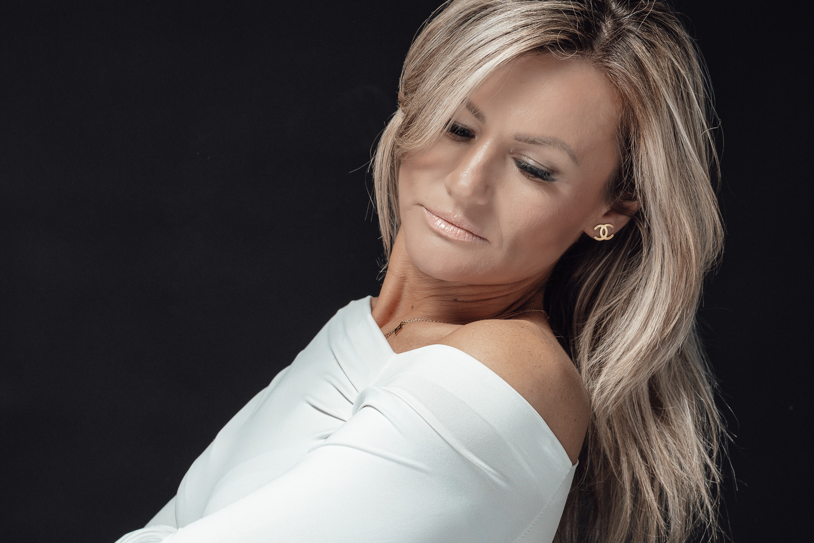 Woman 40+ Portrait voller Eleganz und Ausstrahlung vor dunklem Hintergrund