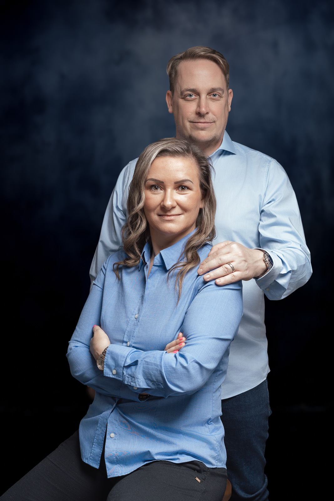 Businessportrait eines Unternehmerpaars mit klarer Präsenz vor dunklem Hintergrund