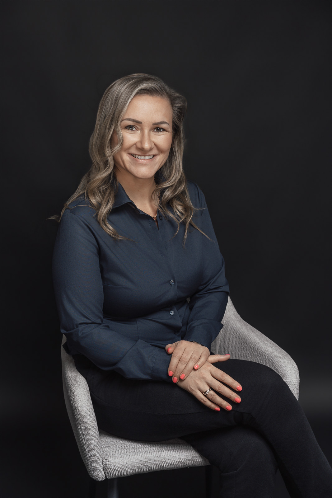 Frauen Portrait mit Eleganz, Stärke und Ausstrahlung vor dunklem Hintergrund