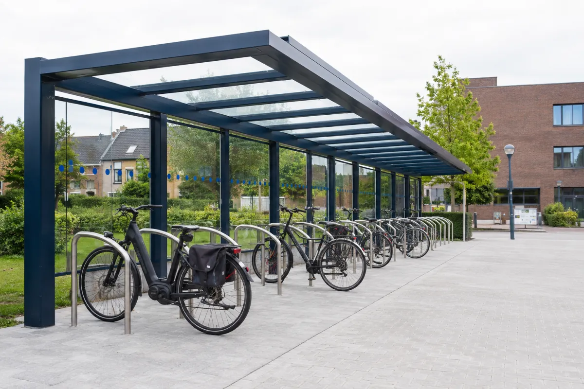 Overdekte fietsenstalling met aanleunbeugels in een openbare ruimte – fietsparkeren door Herva-Doublet