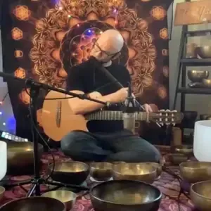 Sonic Yogi Jnathan adams with his guitar and other sound therapy instruments around him