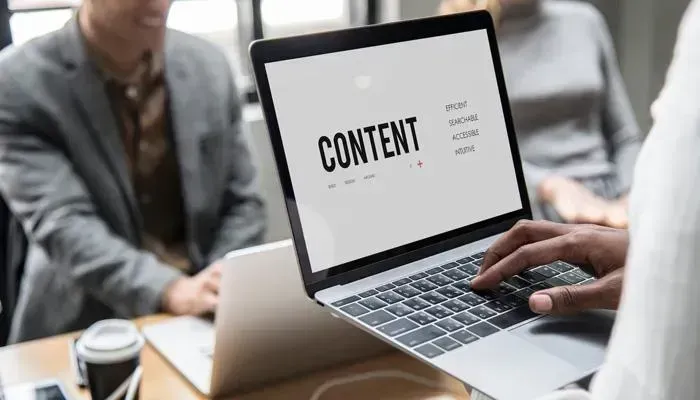 Couple back-to-back with laptop and tablet for team collaboration