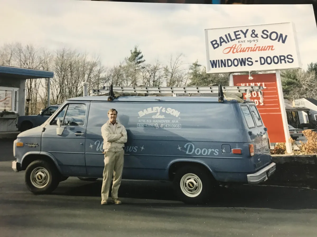 Bailey & Son van parked outside, showcasing "Windows" and "Doors" signage, with a person standing beside it, representing North Star-Bailey's long-standing service in home improvement since 1945.