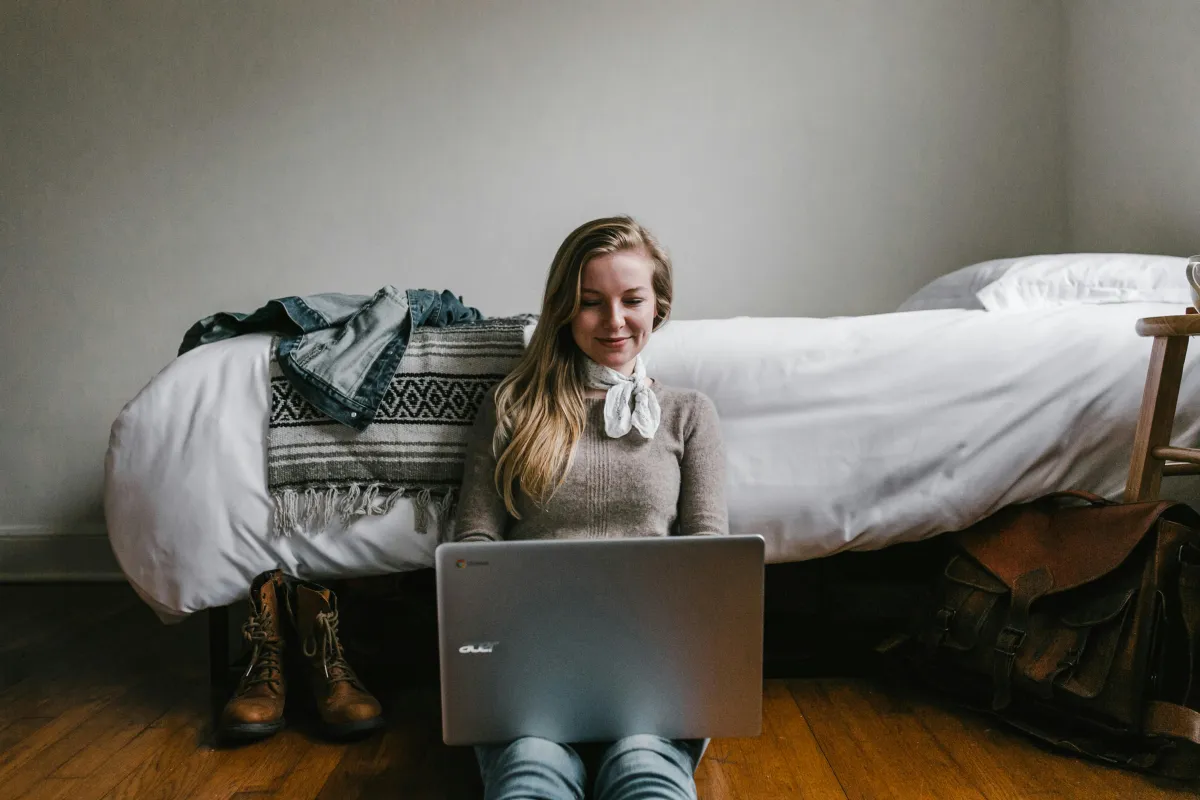 Blonde woman using laptop on floor