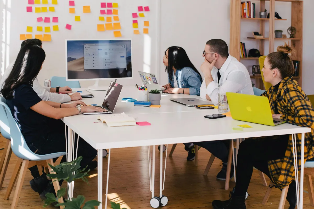 Group of people sitting at a desk while looking at computer