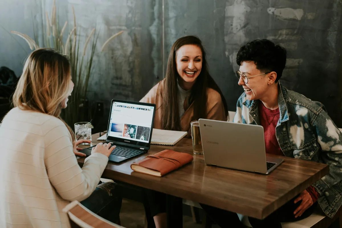 Three women sitting at coffee shop laughing