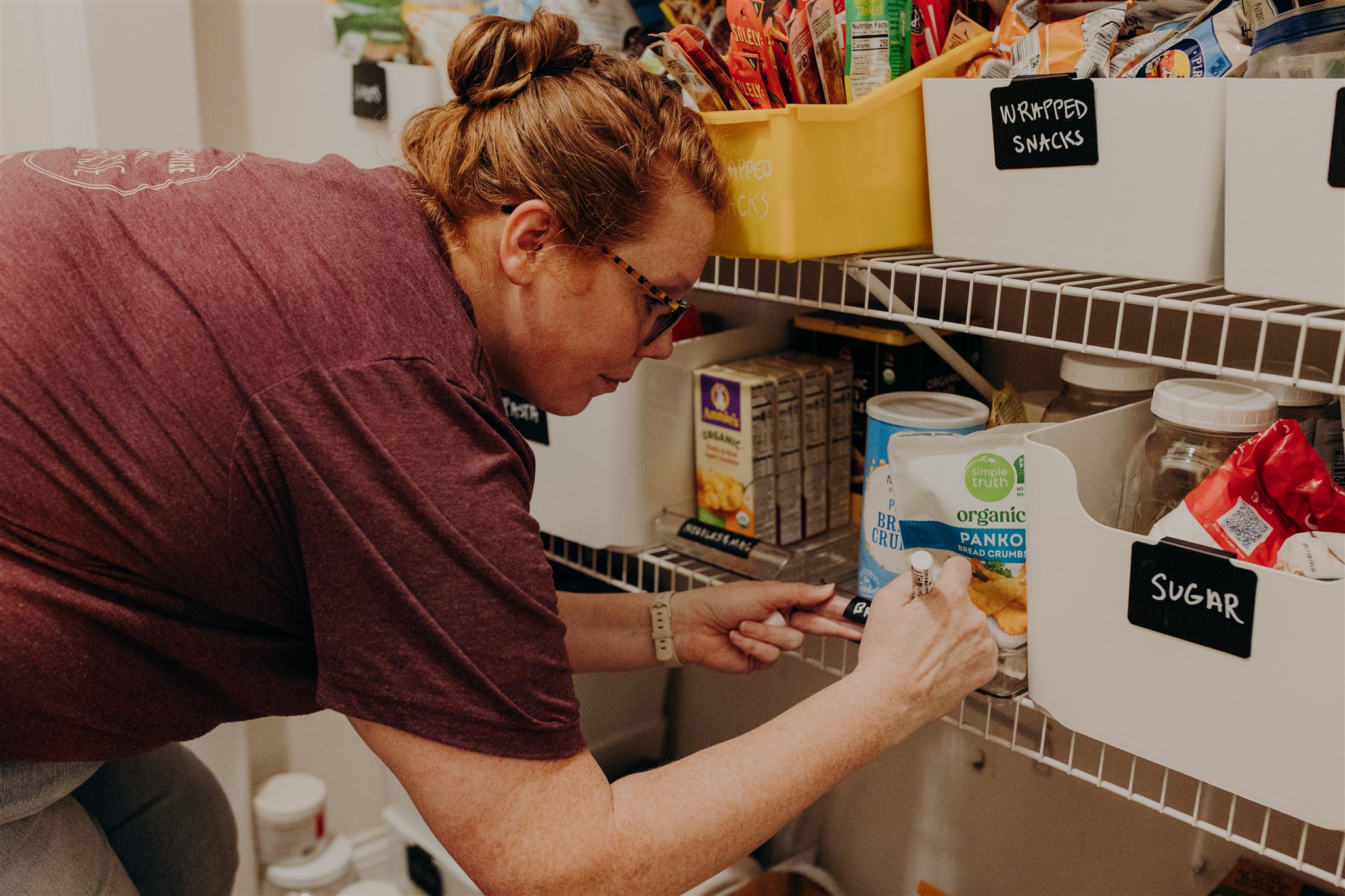 Image of Katie owner of Organize With Kurnsie organizing a pantry
