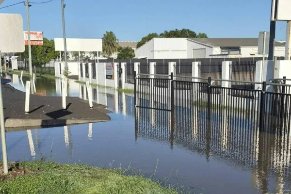 Floodwaters rising in Bundaberg as local support workers assist residents with evacuation and safety during severe flooding, highlighting community teamwork, emergency response, and care for vulnerable participants.