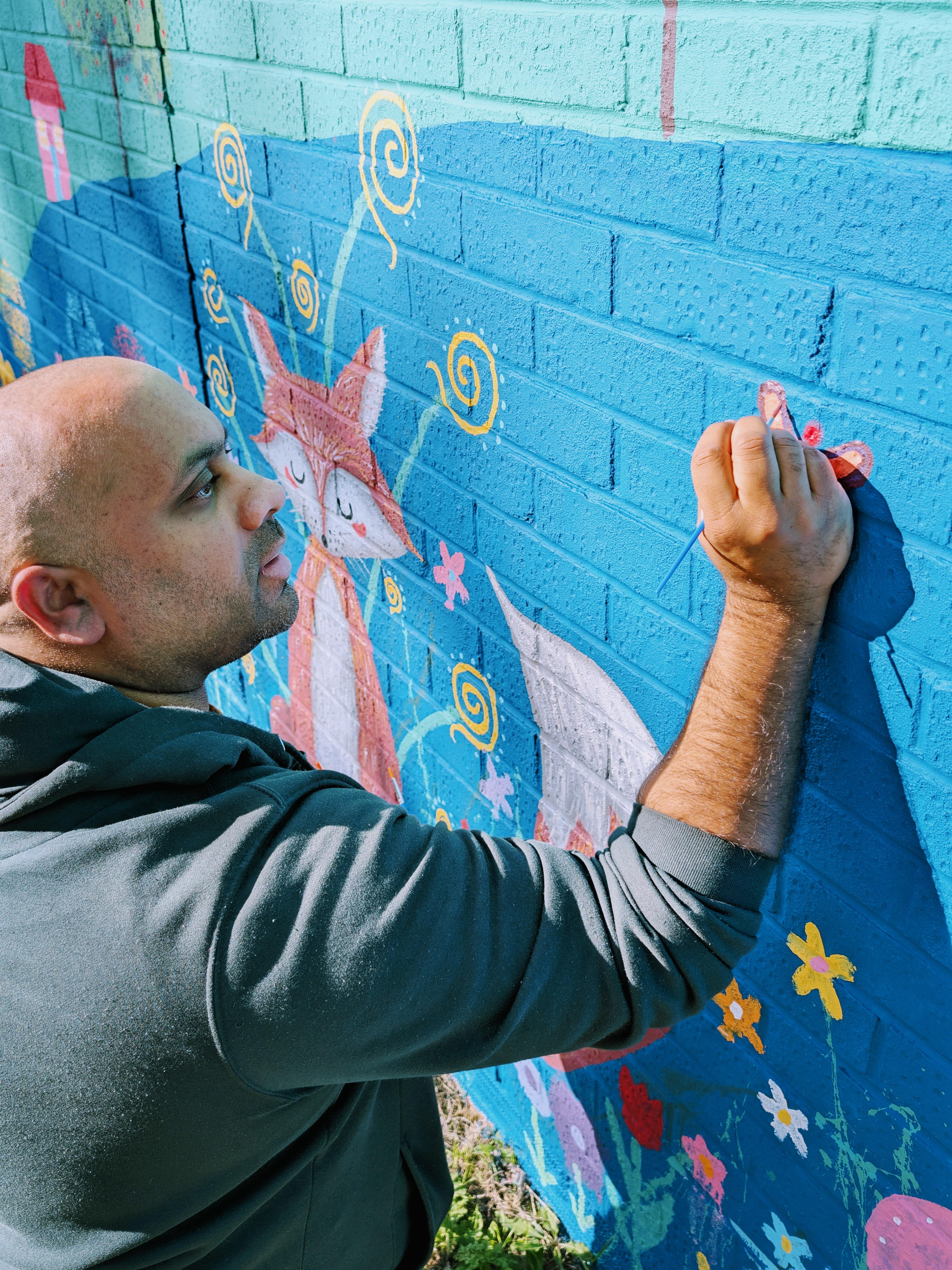 Budding artist contributing to the Wild & Wonder™ community mural by Janine Tonkin™, expressing creativity through guided community painting.