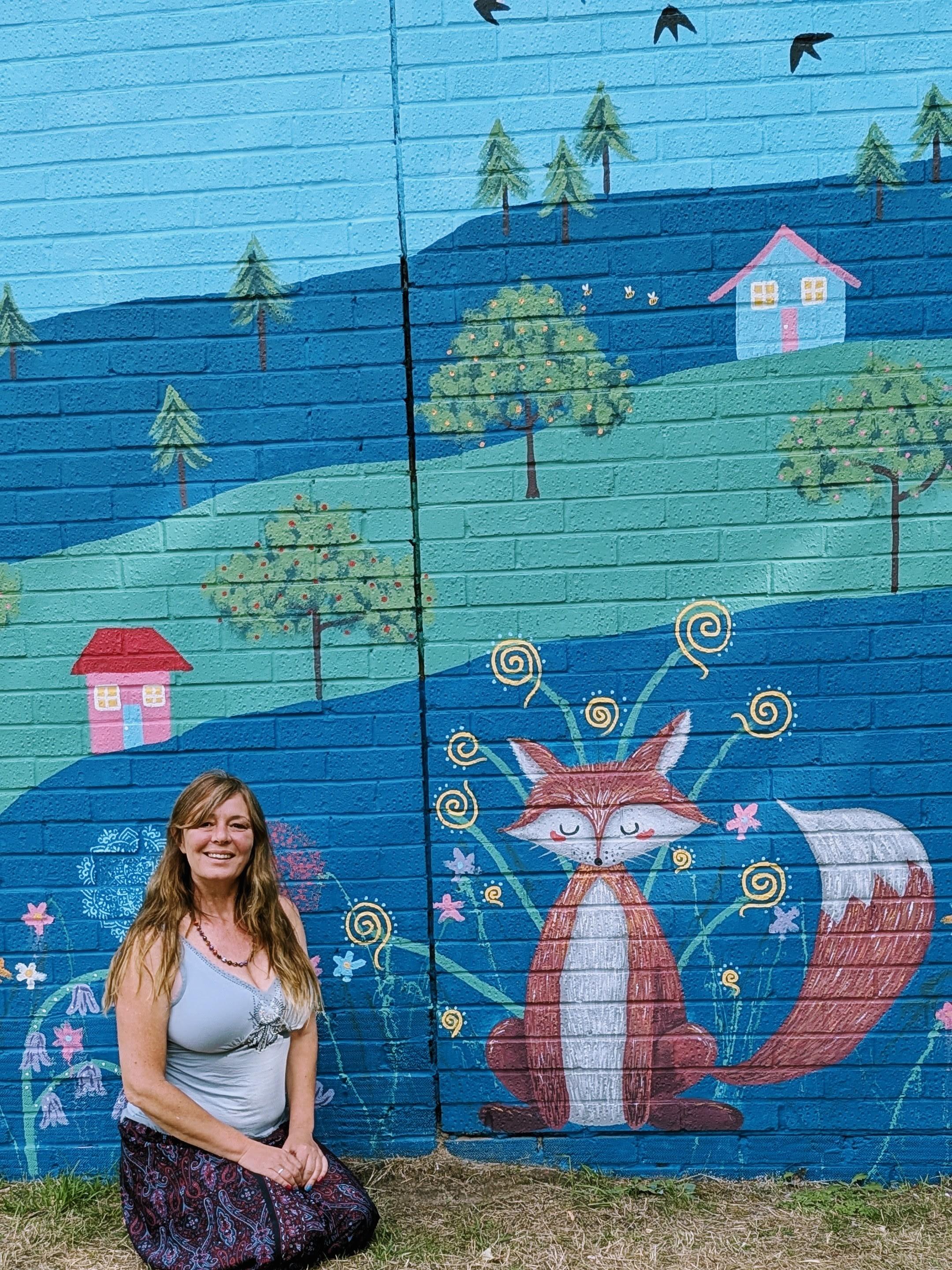 Janine Tonkin beside the Wild and Wonderful community mural featuring a fox inspired by resident feedback at Campion House, Bracknell.