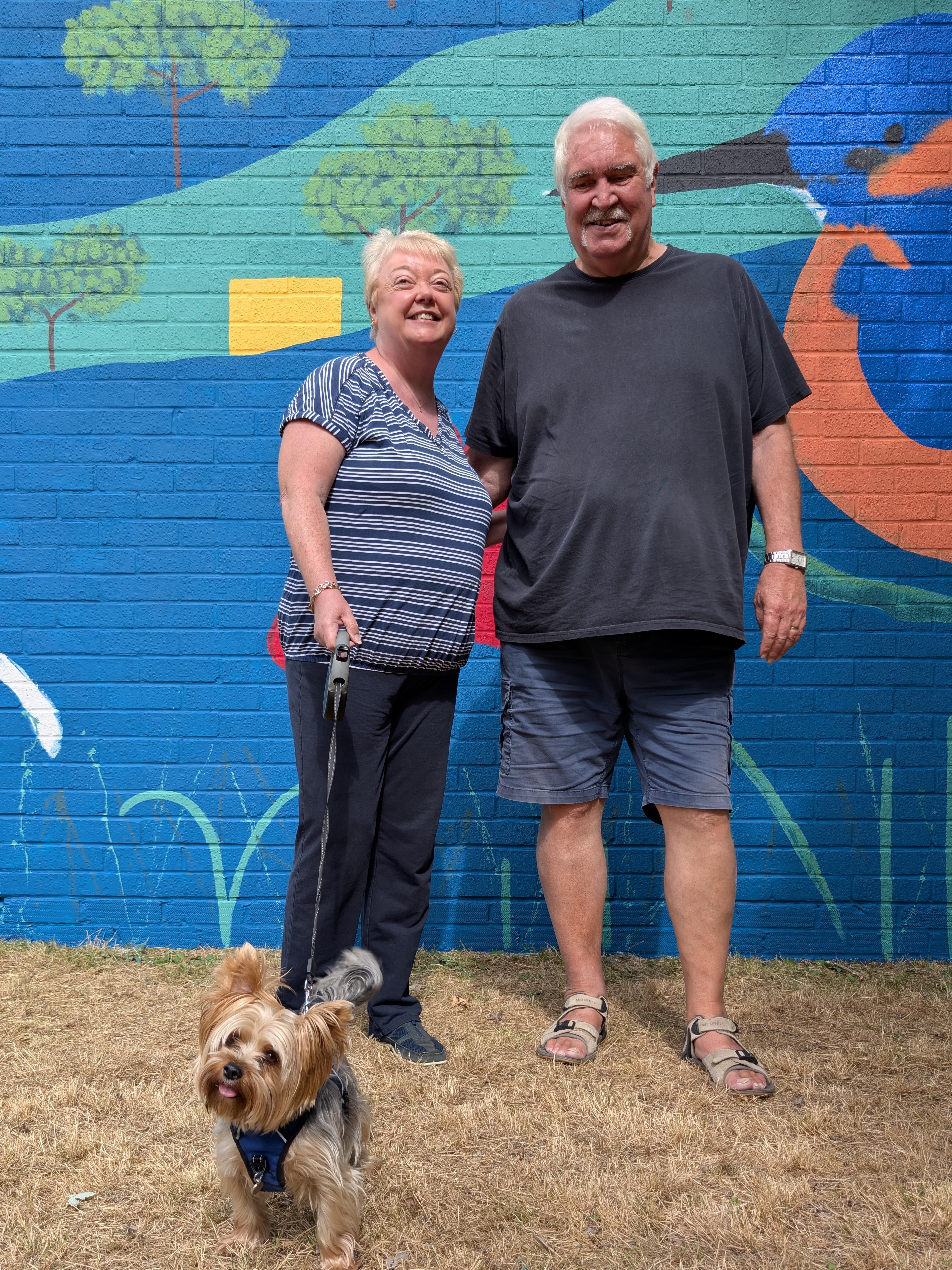 Residents with their dog enjoying the Wild & Wonder™ community mural by Janine Tonkin™ at Campion House, Bracknell, celebrating creativity and community connection.