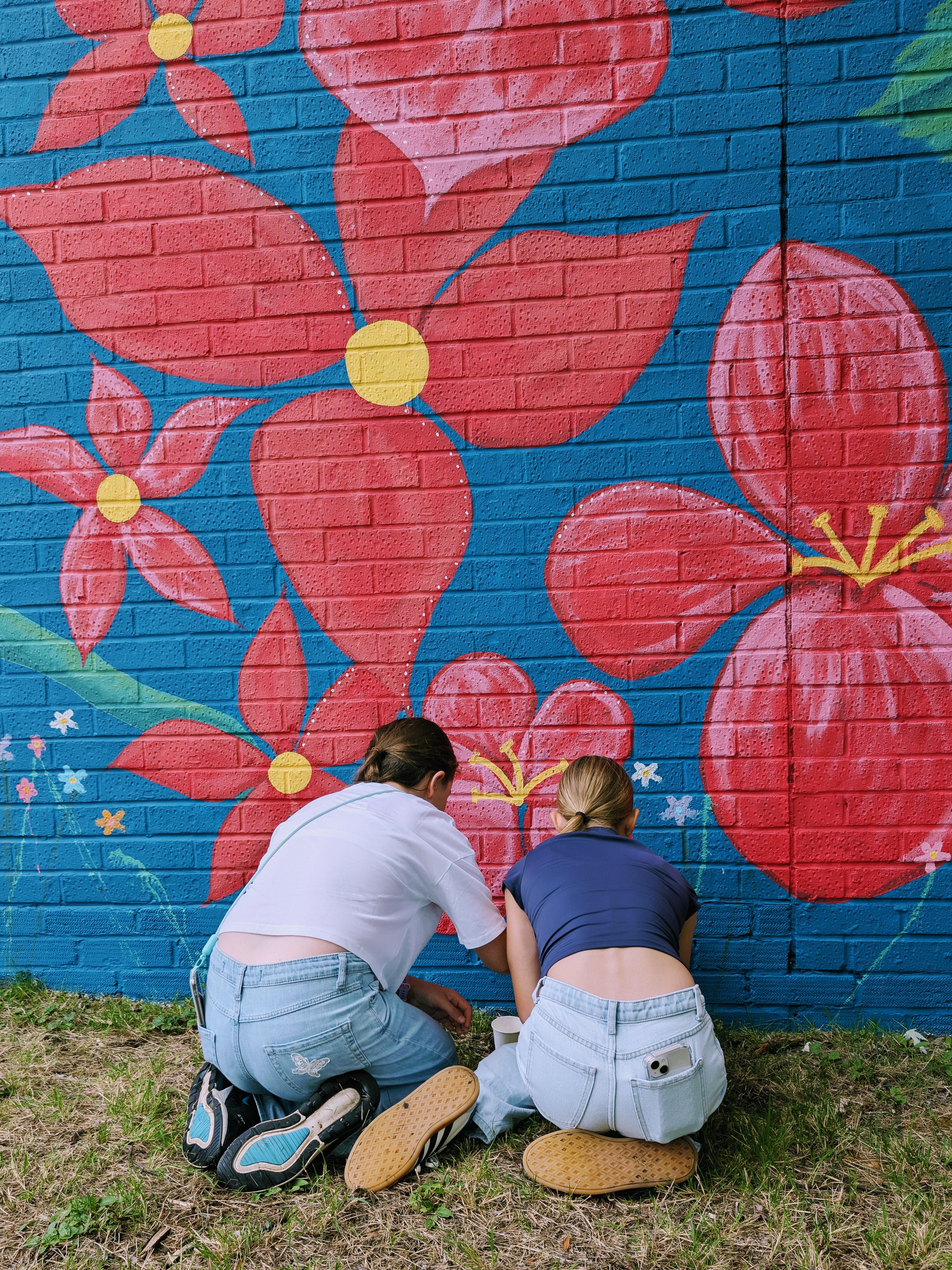 Community members contributing to the Wild & Wonder™ mural through guided interactive painting by Janine Tonkin™
