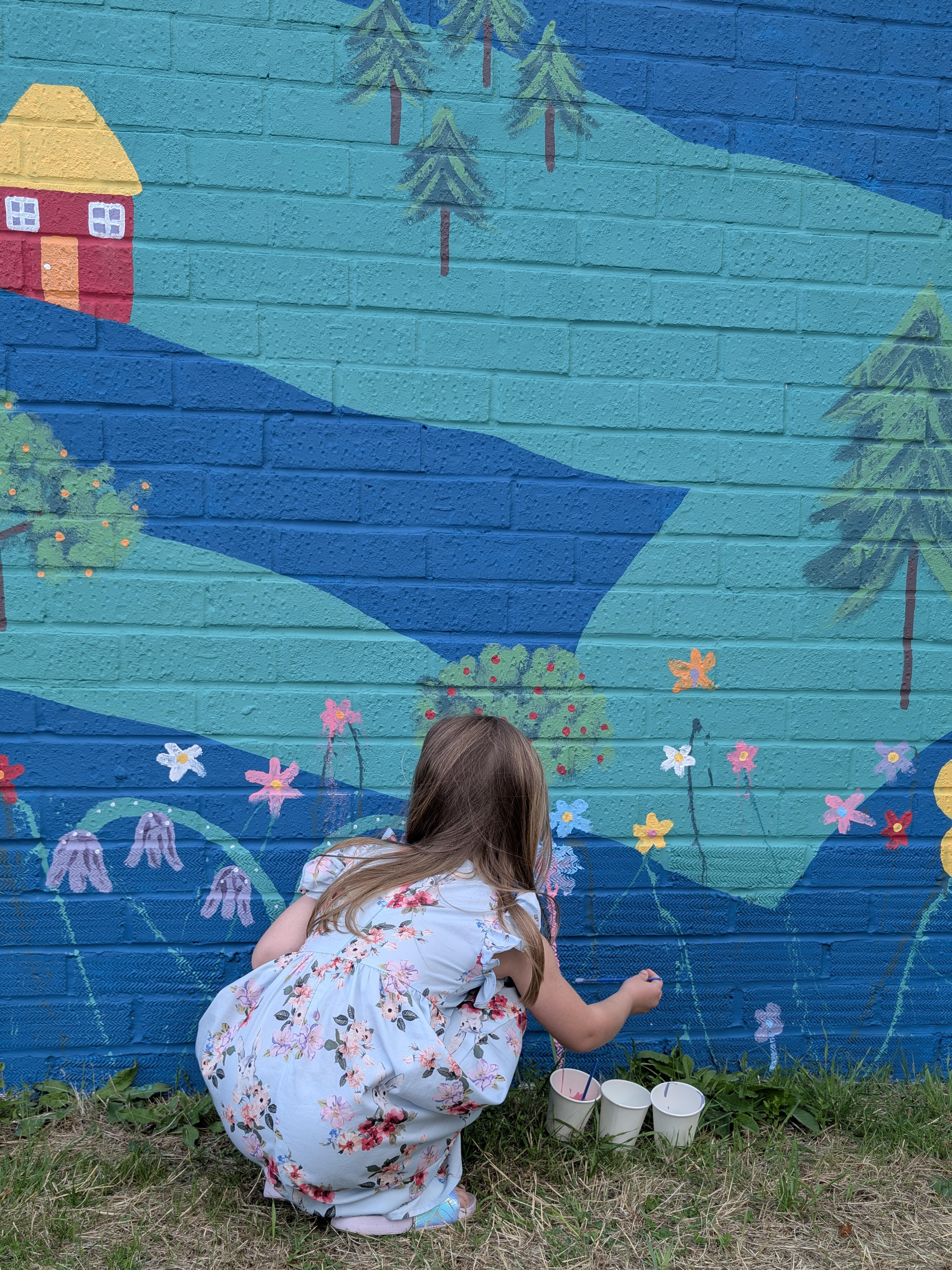 Resident painting their own flower during the Wild & Wonder™ community mural celebration by Janine Tonkin™