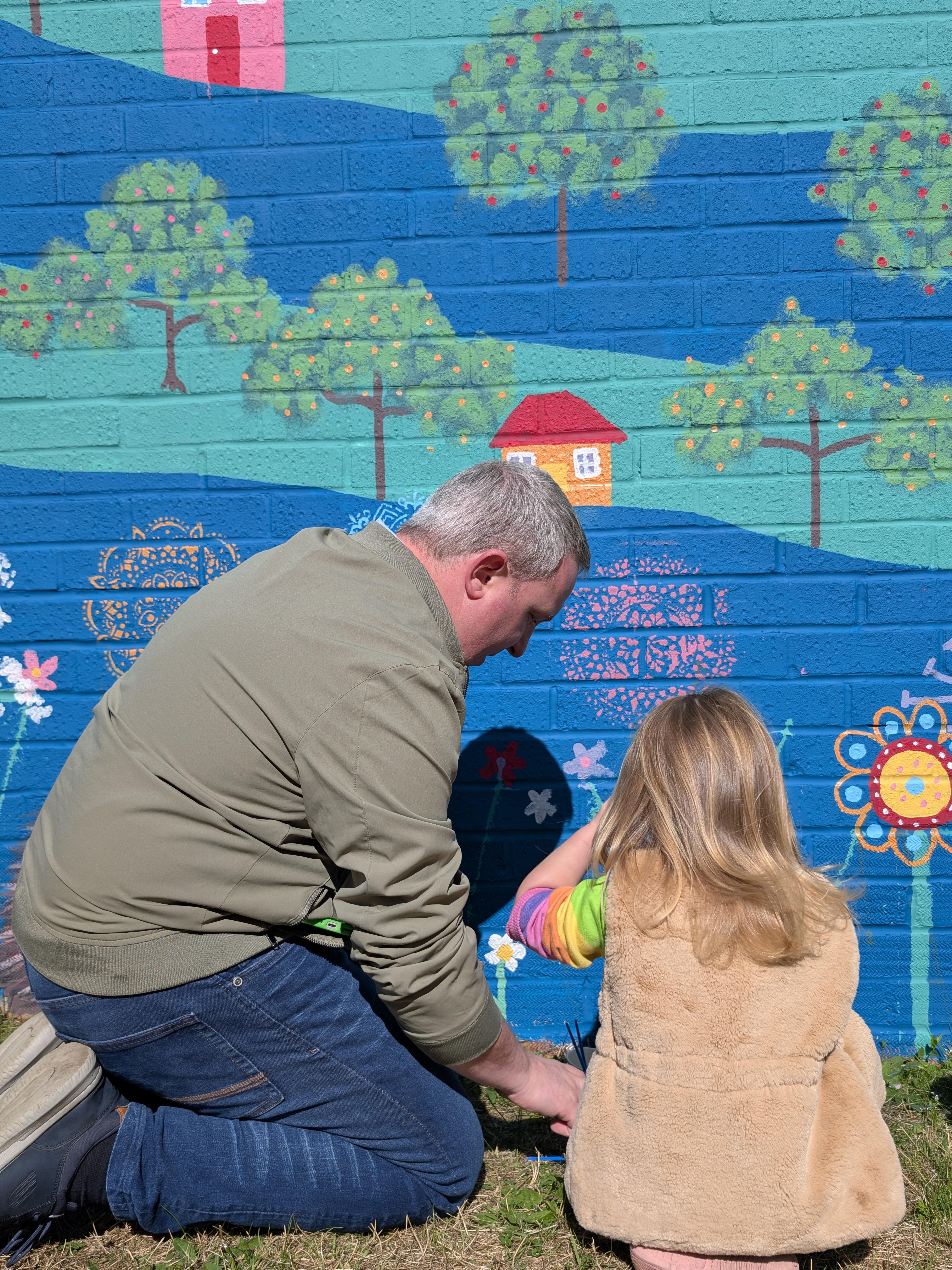 Parent and child creating lasting memories while contributing to the Wild & Wonder™ community mural by Janine Tonkin™