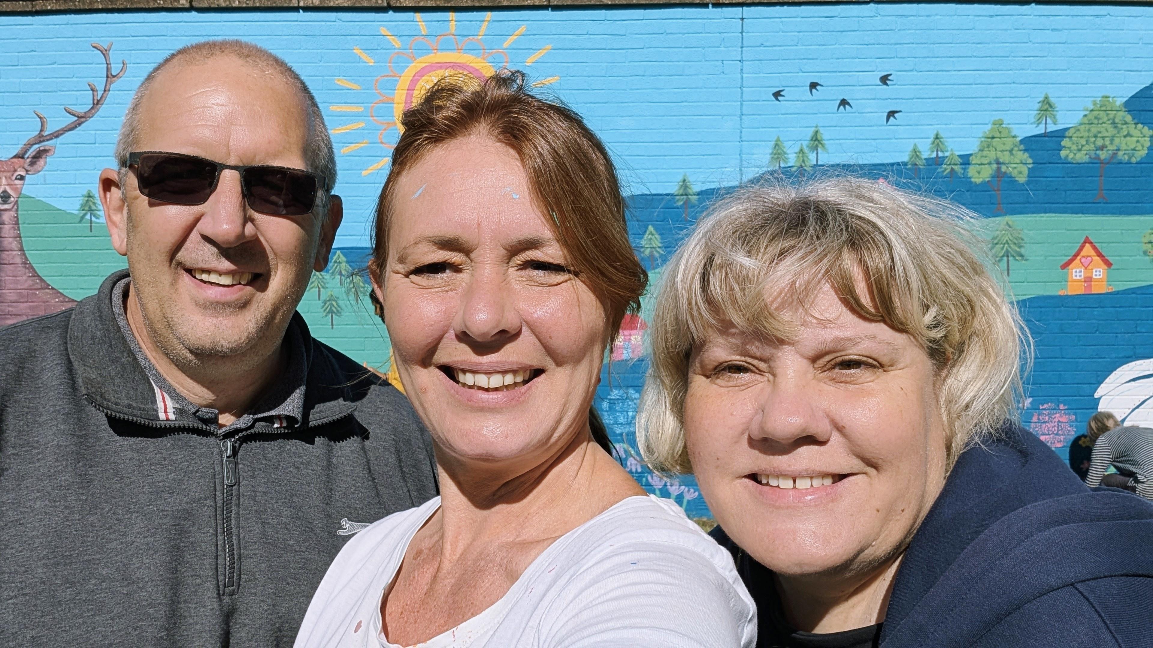 Janine Tonkin™ celebrating the Wild & Wonder™ community mural with team members Gary and Caroline Coleman after the successful project.