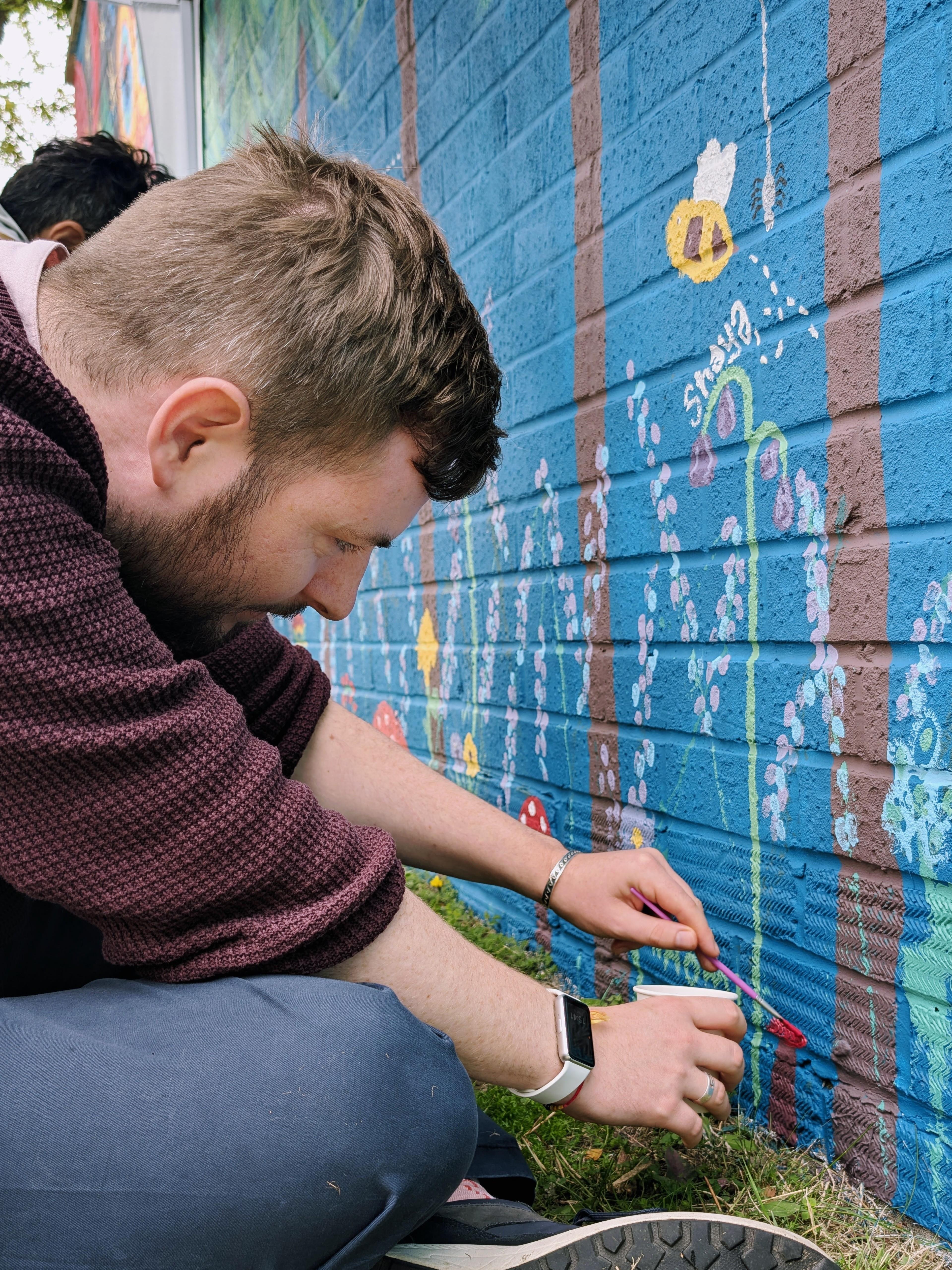 MP Peter Swallow painting his own mushroom on the Wild & Wonder™ community mural under the guidance of Janine Tonkin™