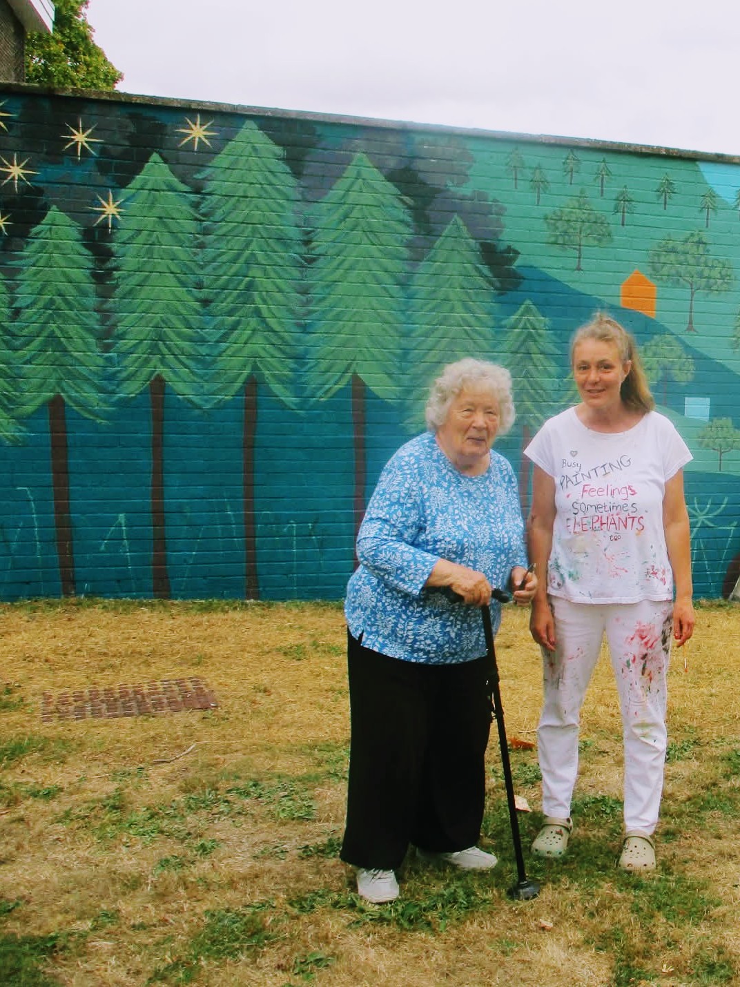 Elderly Resident beside the completed Wild & Wonder™ community mural with Janine Tonkin™ at Campion House, Bracknell. Photo credit: Neil Birkett.
