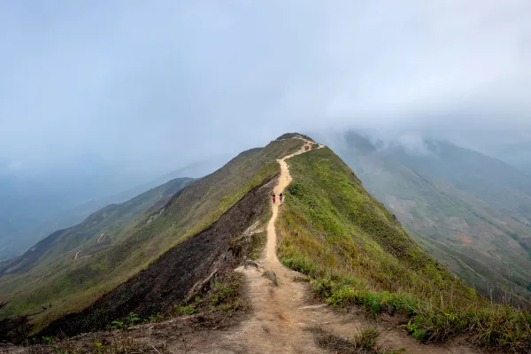 Hiker walking along a mountain ridge, symbolizing moving forward and starting a new chapter.