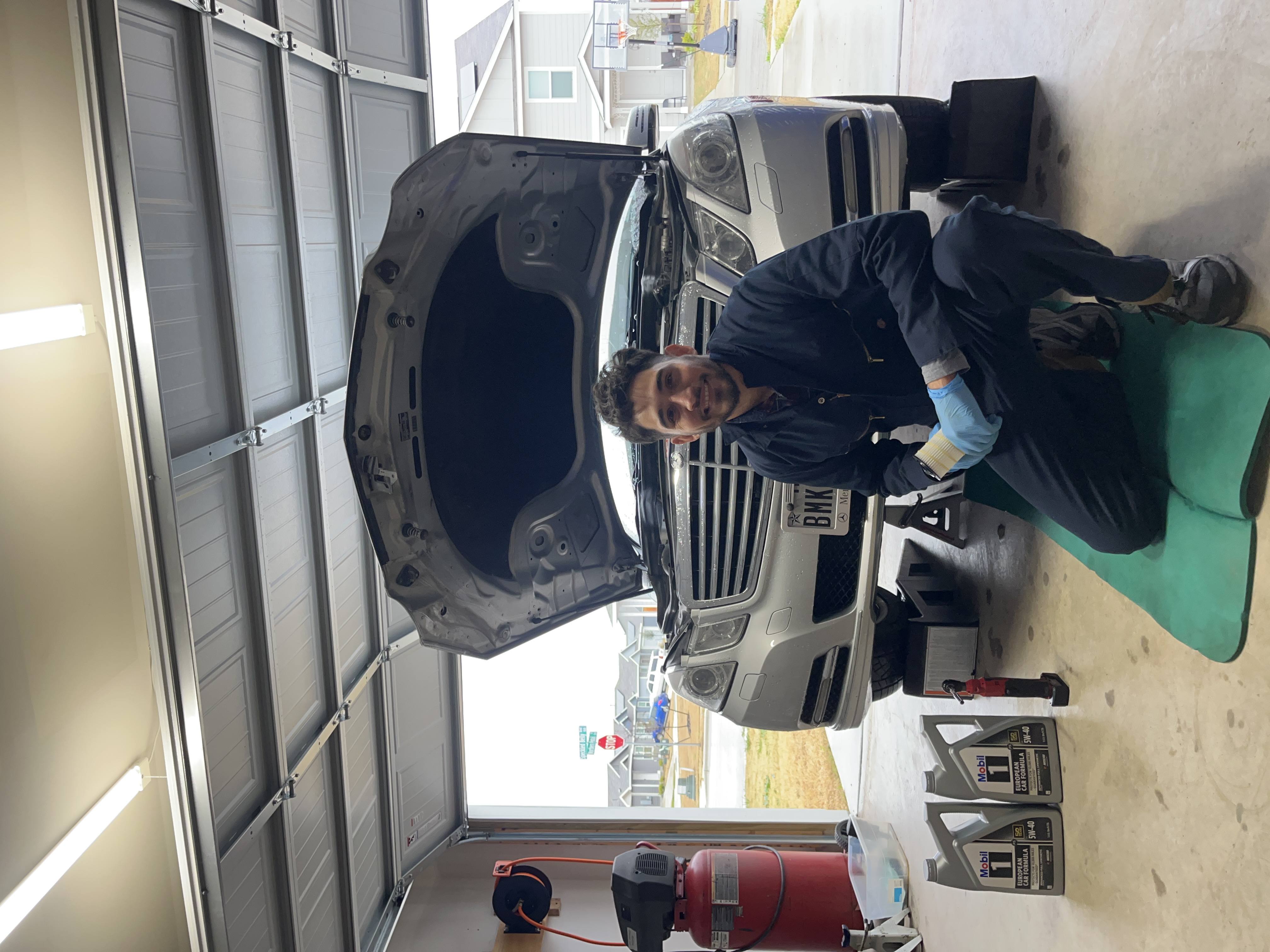 Mechanics working in a garage with open car hoods