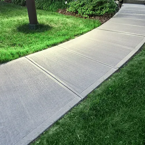 Newly installed concrete sidewalk with clean edges and proper slope for drainage.