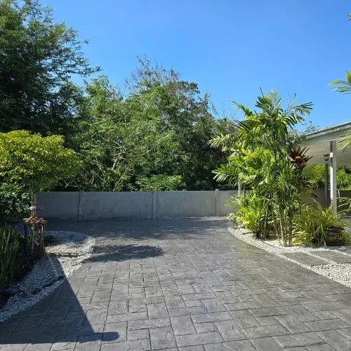 Stamped concrete patio and walkway in Sugar Land, TX, with landscaping and drainage.