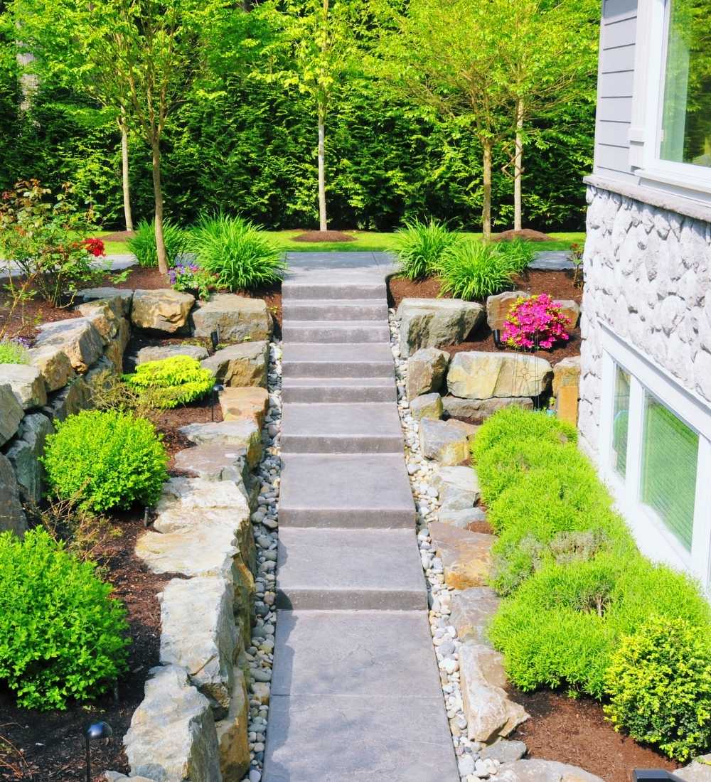 Walkway with green landscaping and mulch next to a house in Lititz, PA