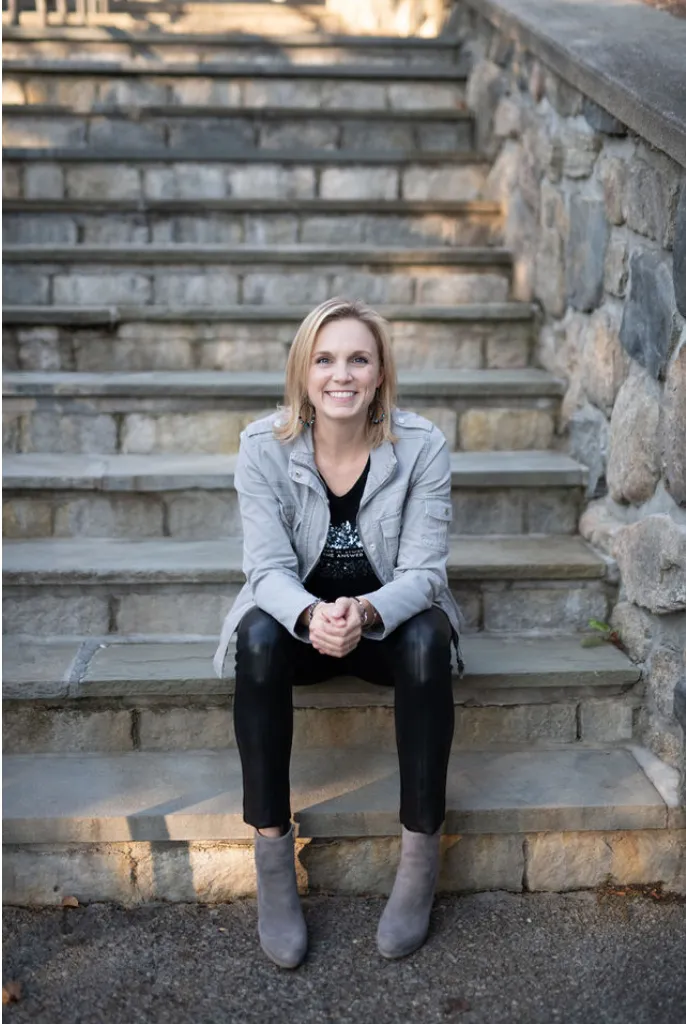 Confident female guide portrait in warm garden light, conveying grounded authority and approachable leadership.