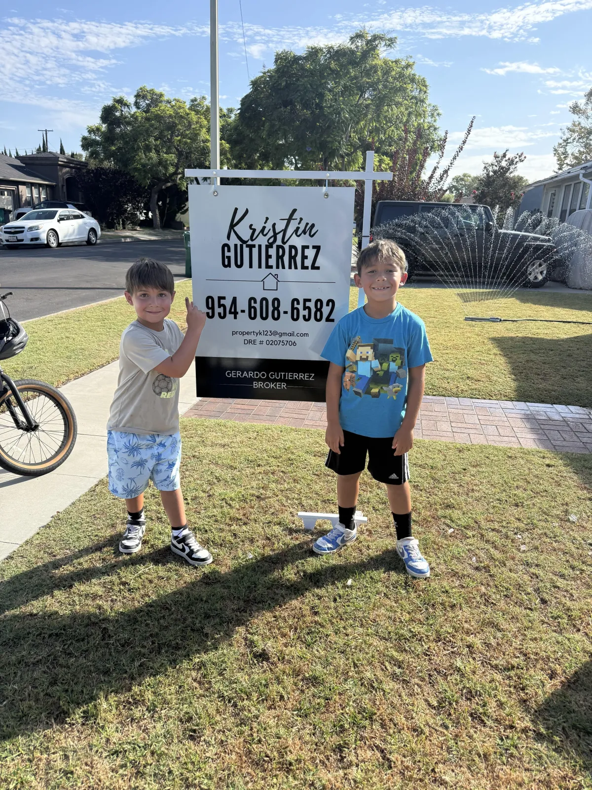 Two children standing in front of a For Sale sign at a Long Beach home listed by Realtor Kristin Gutierrez.