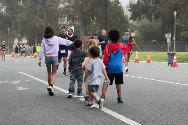 Kids handing out water to runners at Kristin Gutierrez and Gerardo Gutierrez's annual Long Beach Marathon party.