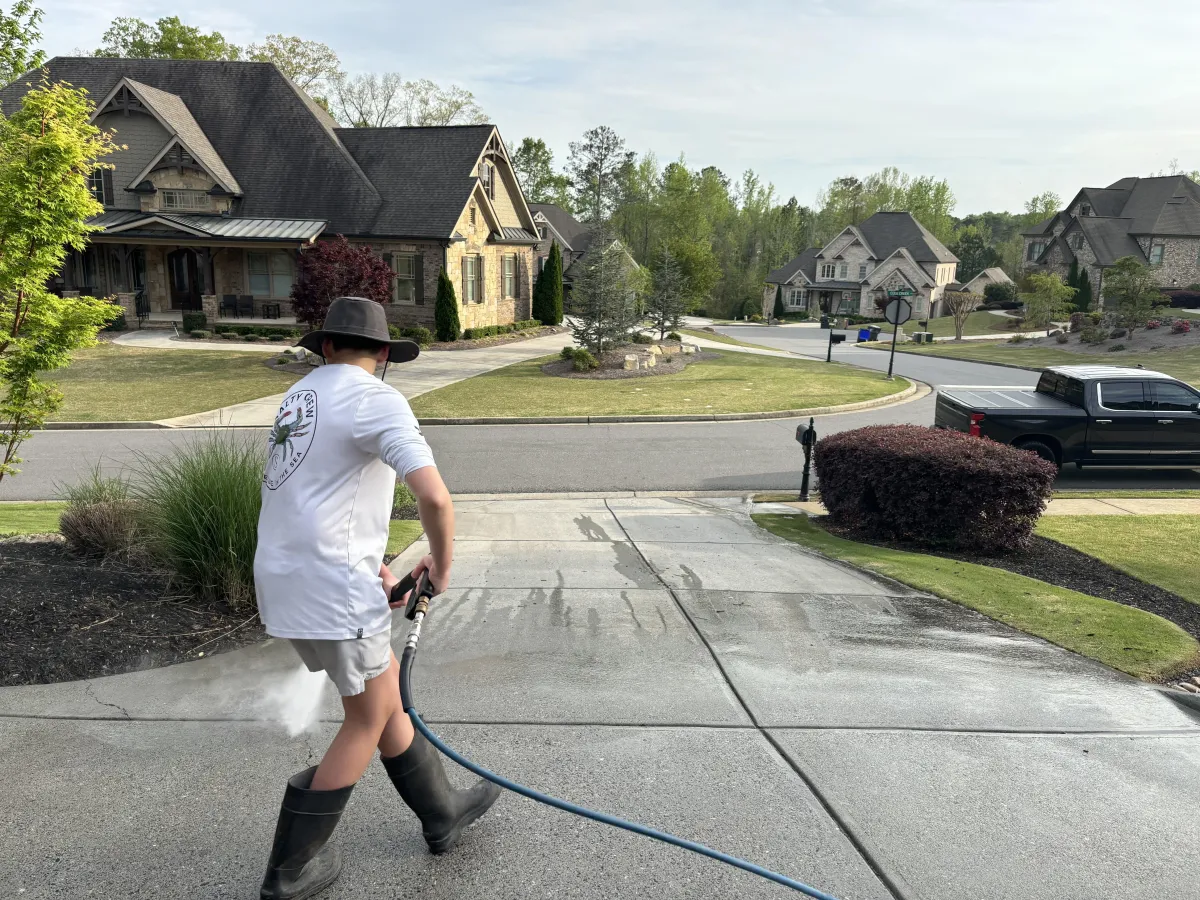 Thunder Wash Pros technician pressure washing a residential driveway in Cumming