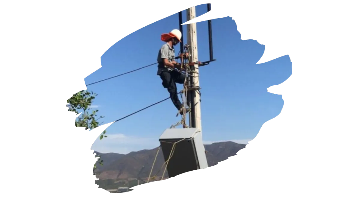 Técnico de telecomunicaciones instalando equipo en poste en zona rural de Chile