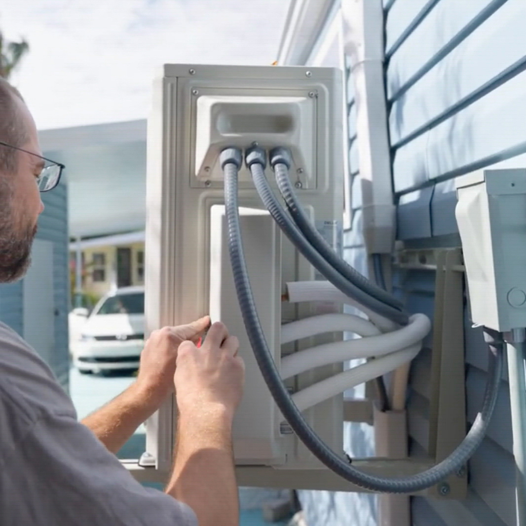 Outdoor air conditioning unit being inspected by HVAC technician