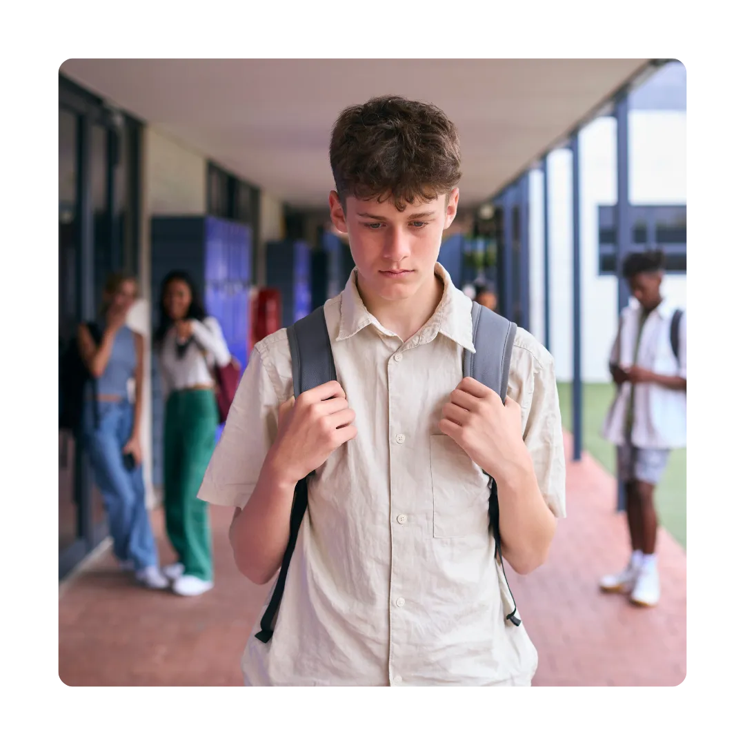sad boy walking through school and being pointed and laughed at and bullied by friends