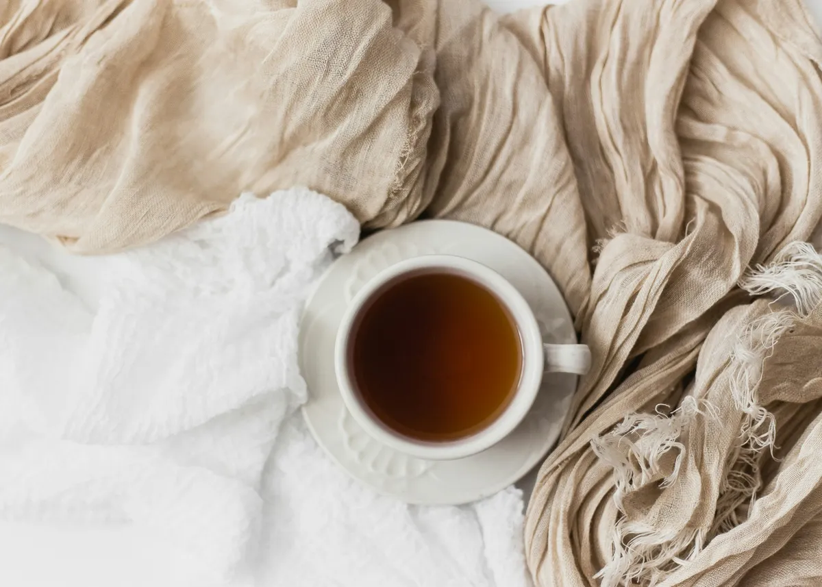 A cup of tea resting on a soft, cosy blanket