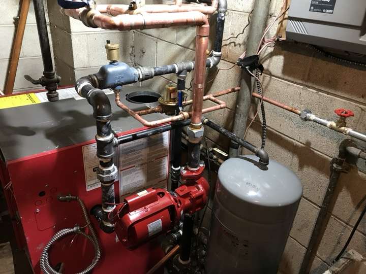 Boiler installation with circulation pumps and copper piping in a residential basement