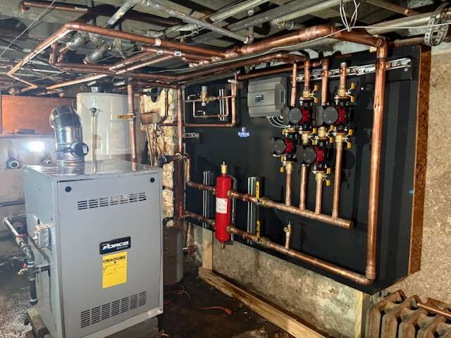 Complete boiler room with hydronic manifold panel and boiler system installed by Supreme Heating