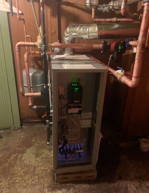 High-efficiency boiler installation with copper piping and digital controls in a home basement