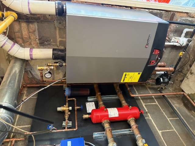 Wall-mounted condensing boiler with copper supply lines installed in a Chicago basement