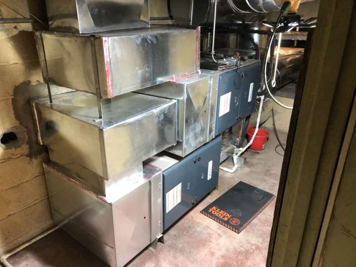 Ductwork installation with sheet metal supply runs in a residential basement