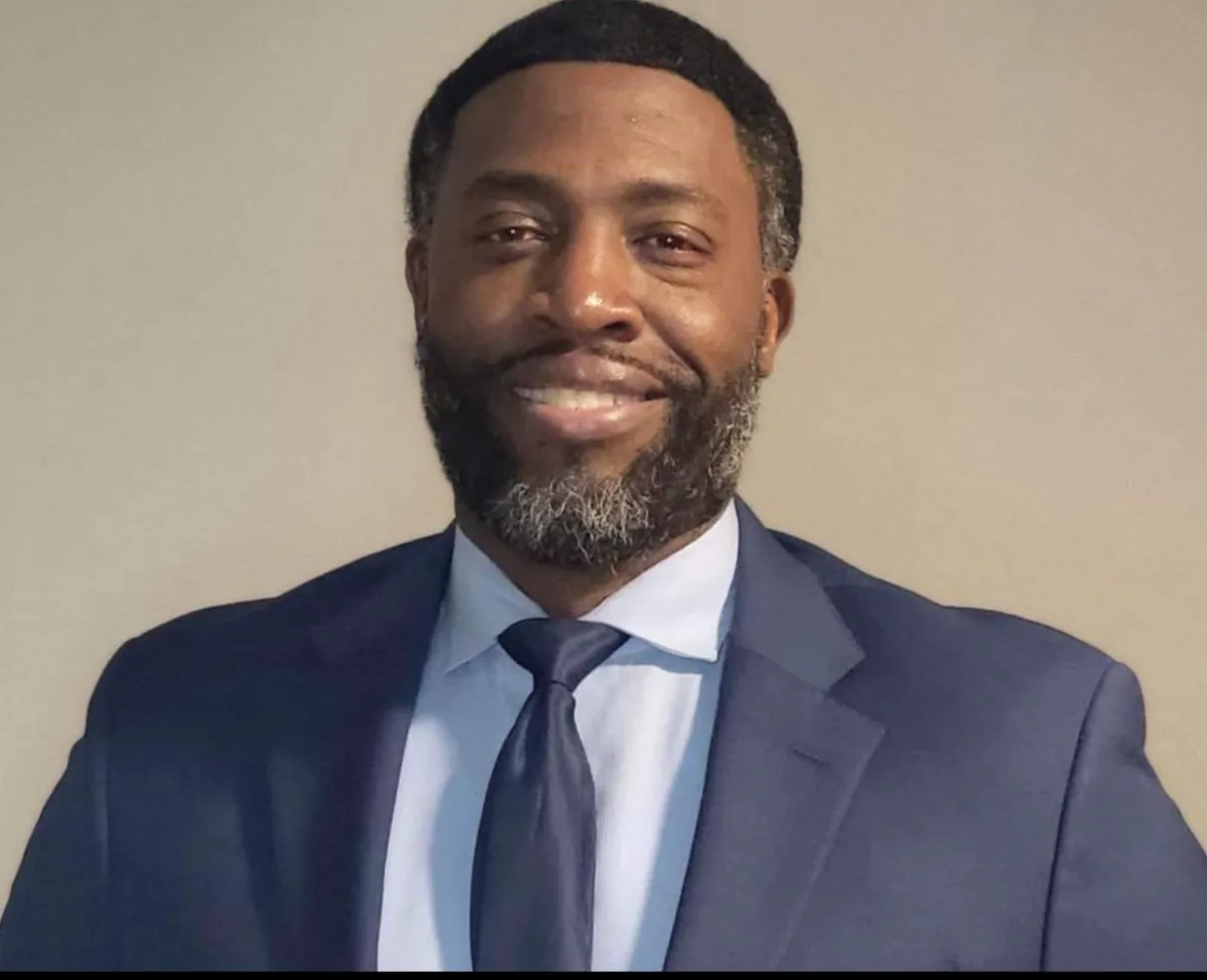 Professional photo of trading coach Marcus Green smiling with city skyline in background