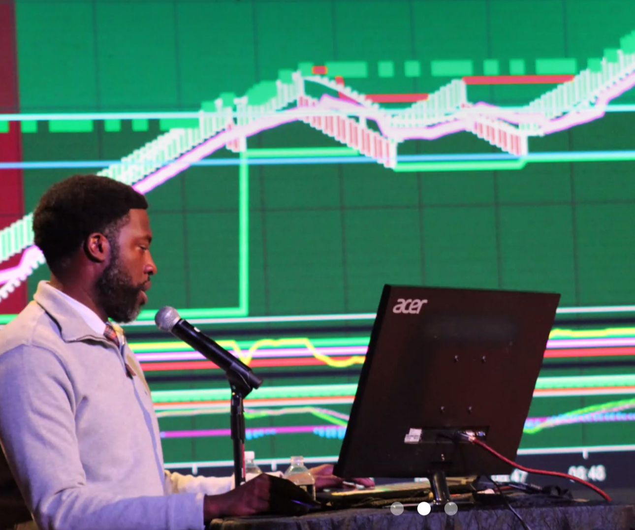 Realistic photo of a trader reviewing charts on multiple monitors with aqua highlights