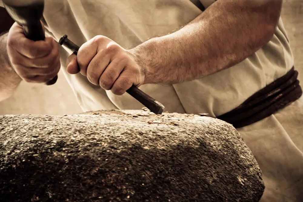 Close-up of craftsman chiseling stone – symbolizing strength and protection with Stonebridge Insurance