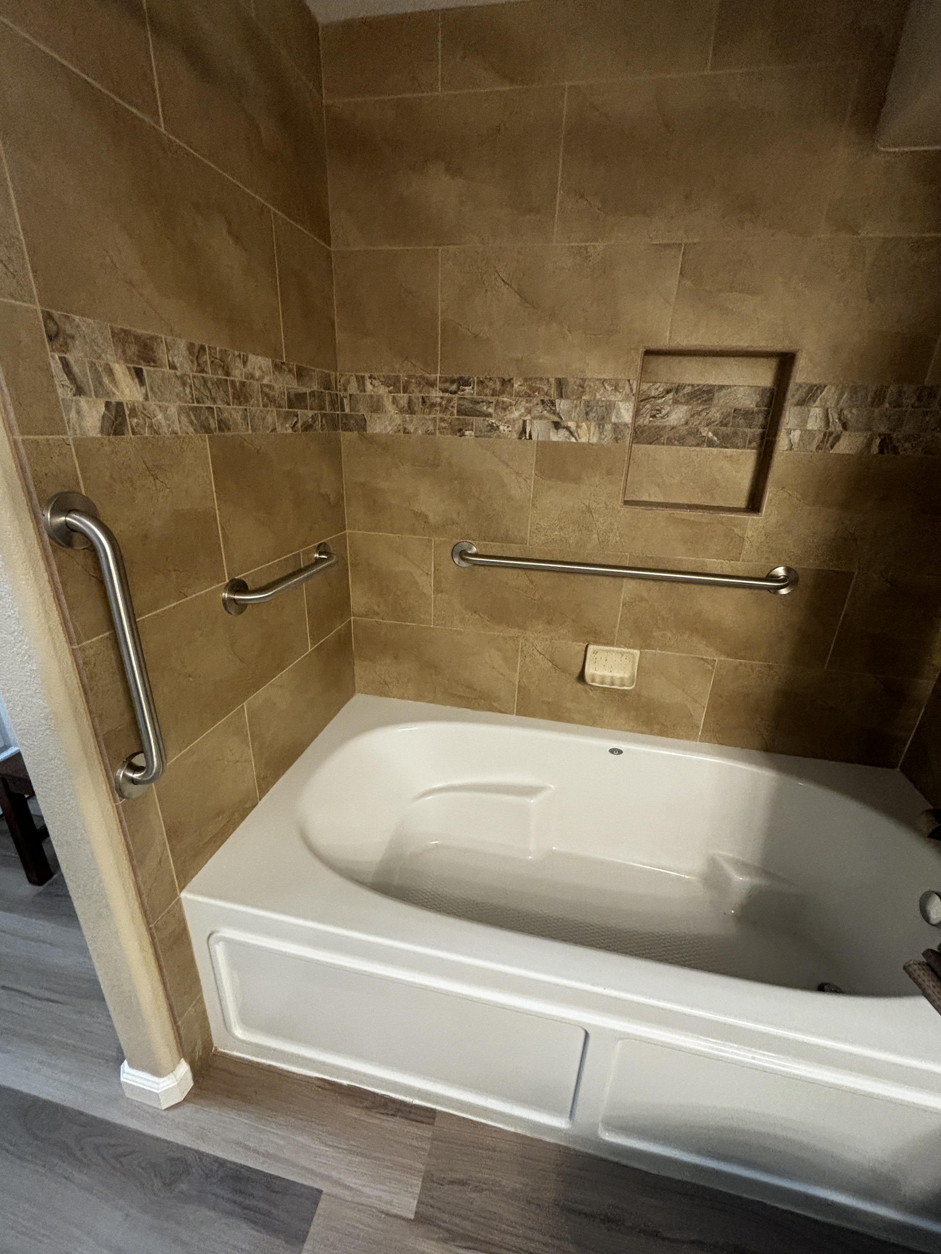 Tiled walk-in shower with grab bars installed for aging-in-place safety