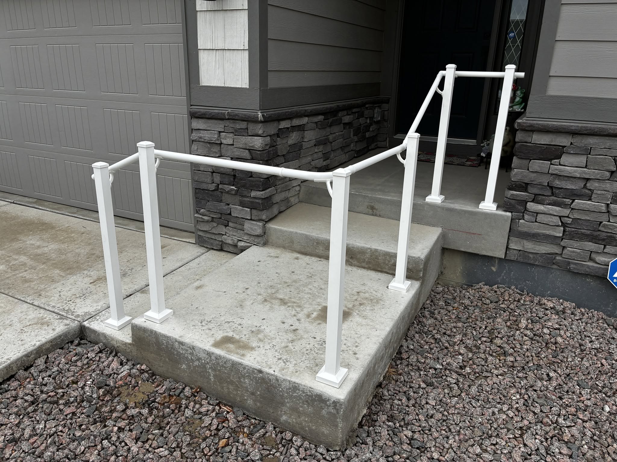 White aluminum handrail installed on front porch steps for safe entry