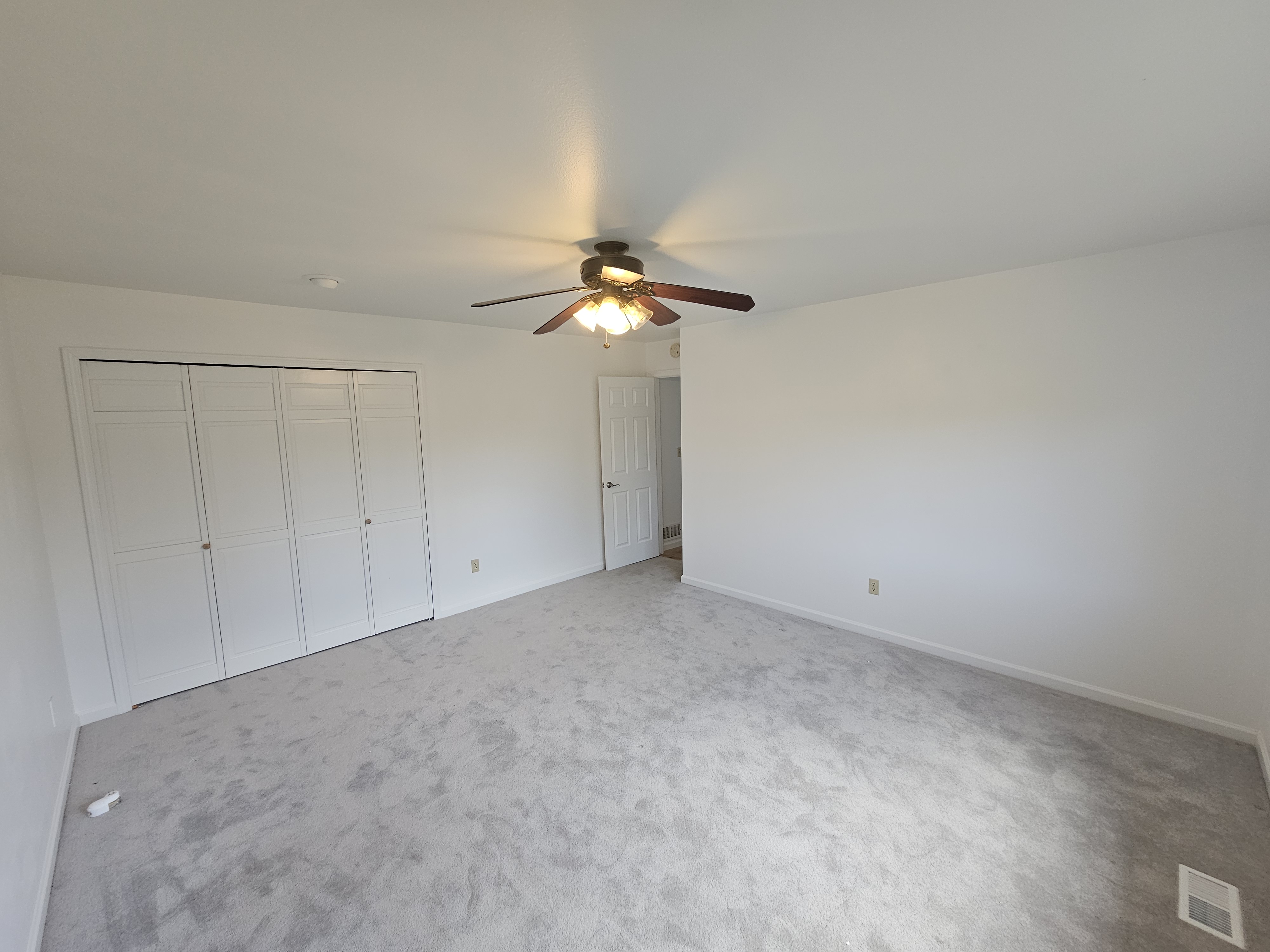 Empty bedroom after interior painting with fresh white walls and gray carpet